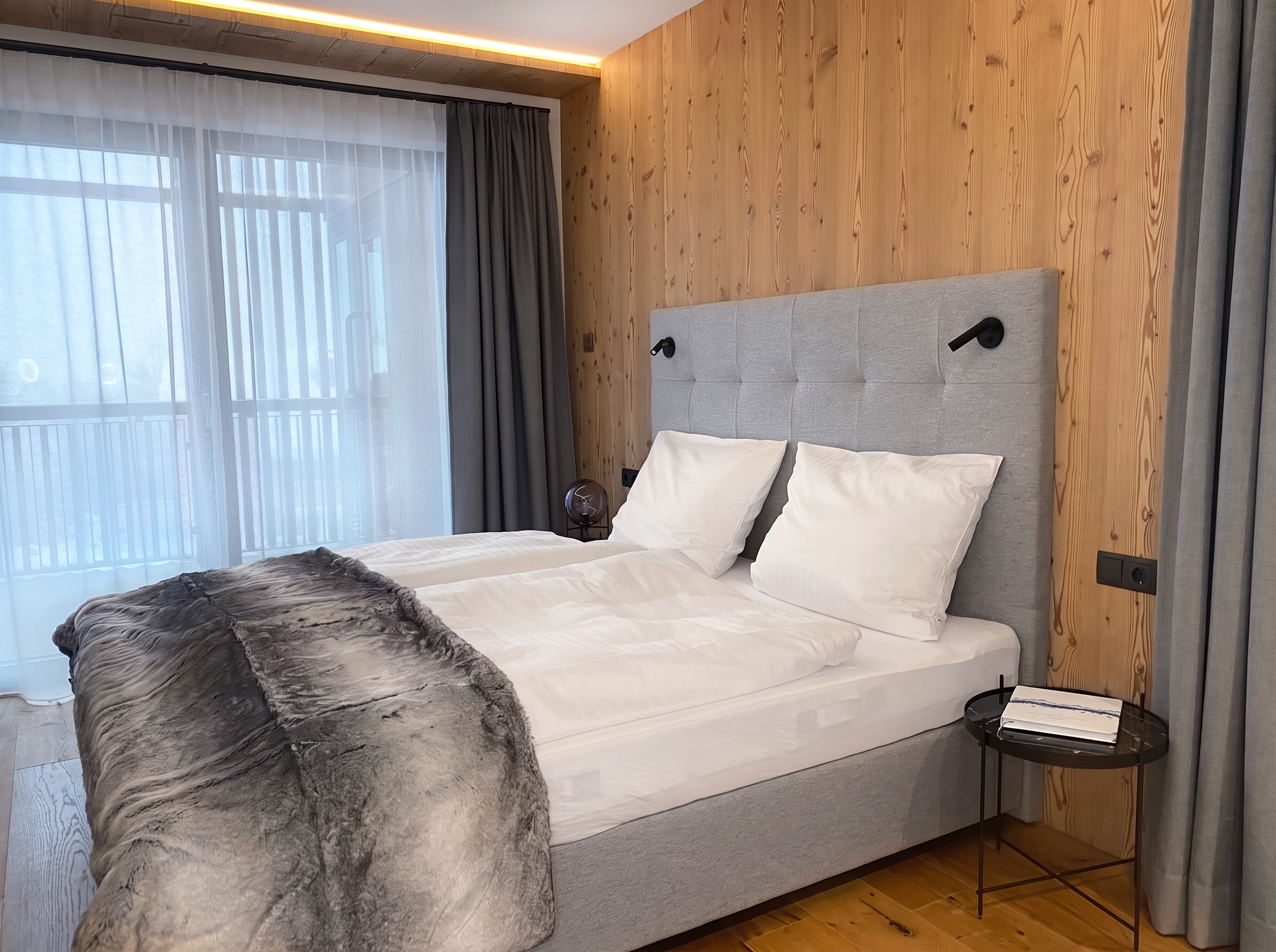 Master-Schlafzimmer im Florisa Mountain Penthouse mit Doppelbett und Bergblick auf die Dolomiten
